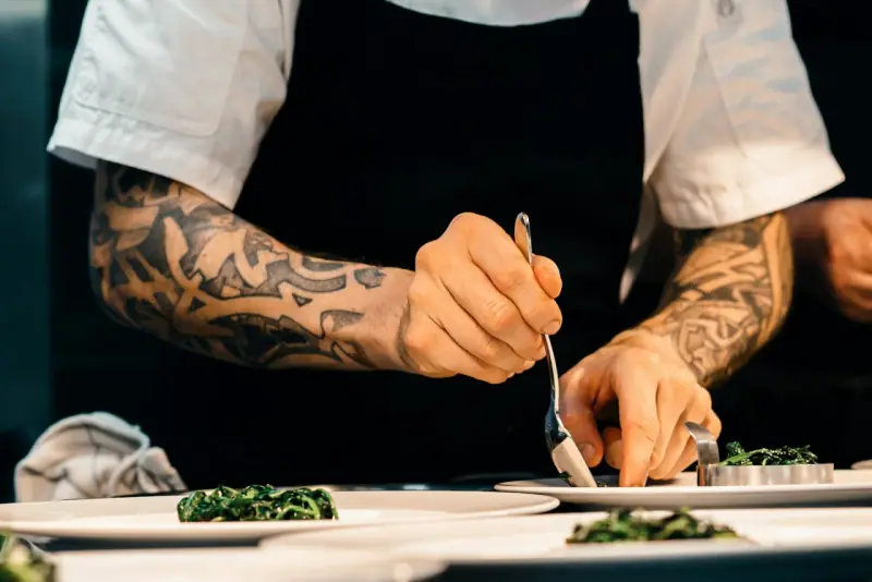 Hospitality professional arranging food carefully on a plate