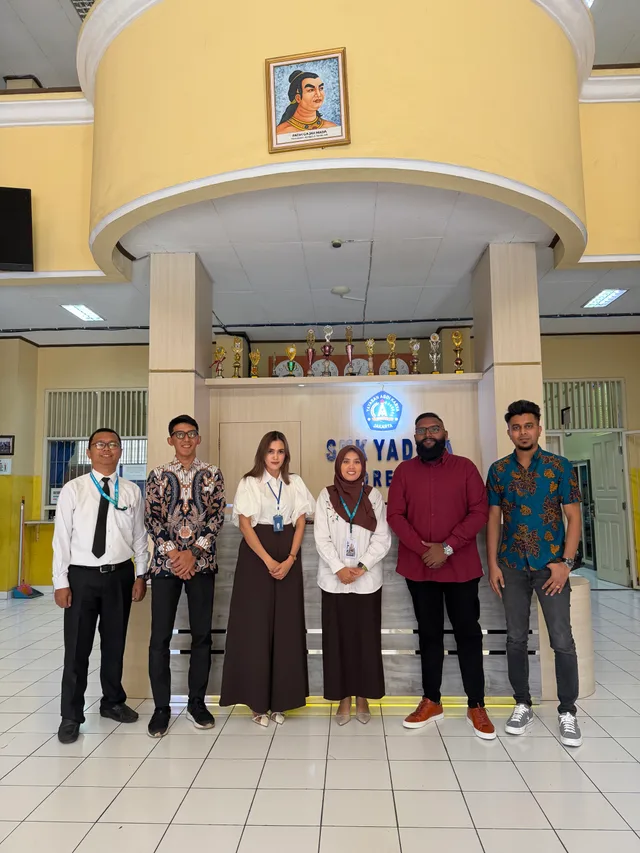 Visitors gathered for a photograph at a campus entrance